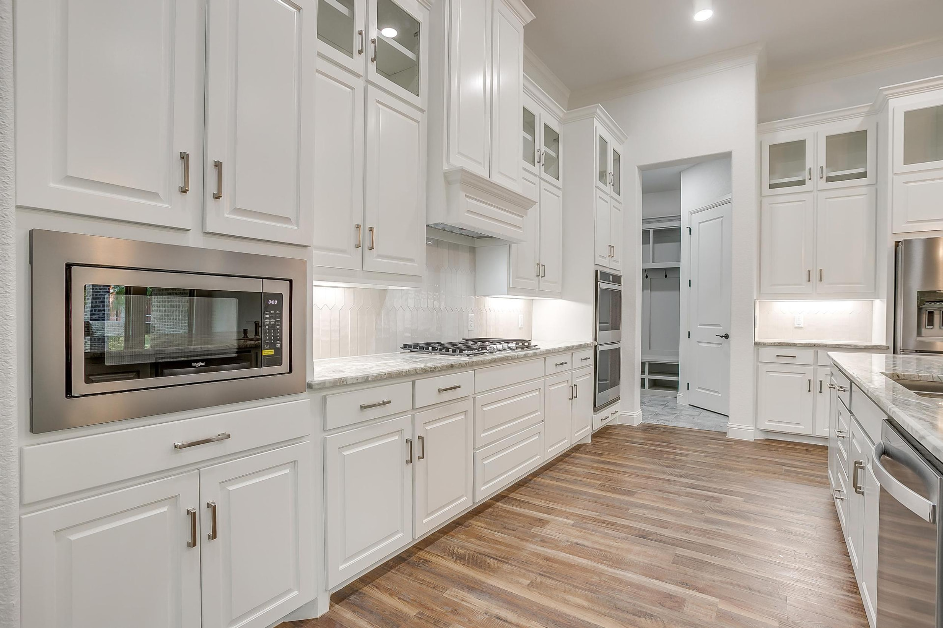 Stainless microwave built into white shaker cabinetry