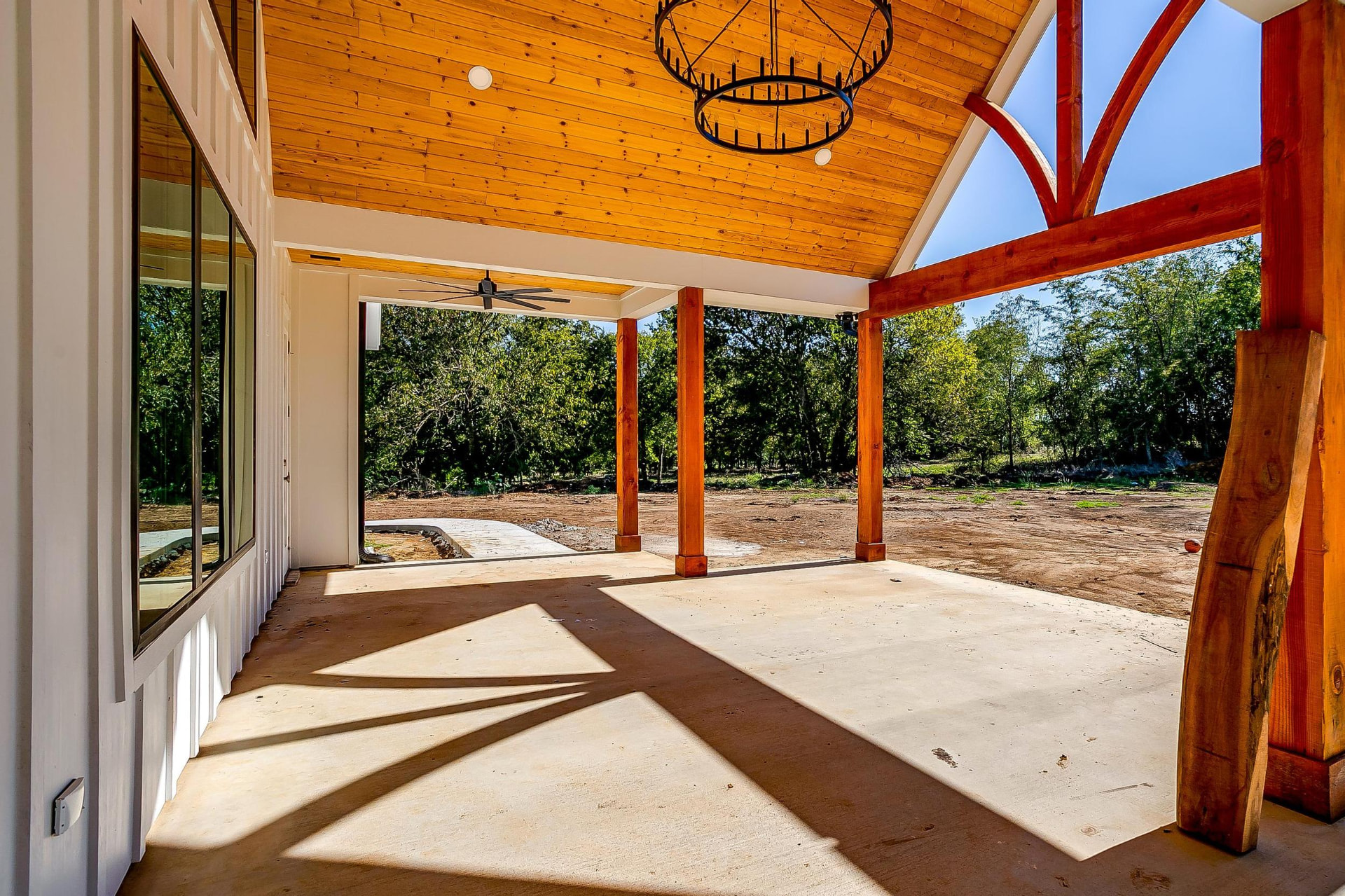 Vaulted outdoor living pavilion with cedar trusses and a chandelier