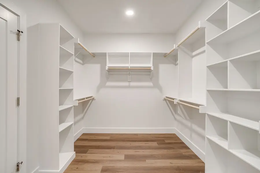 Large primary walk-in closet with floor-to-ceiling built-ins