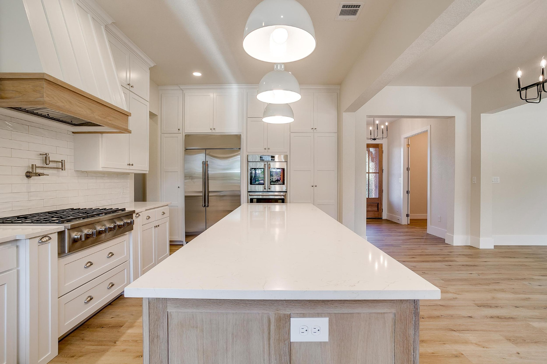 Kitchen island looking toward the professional gas range and hood