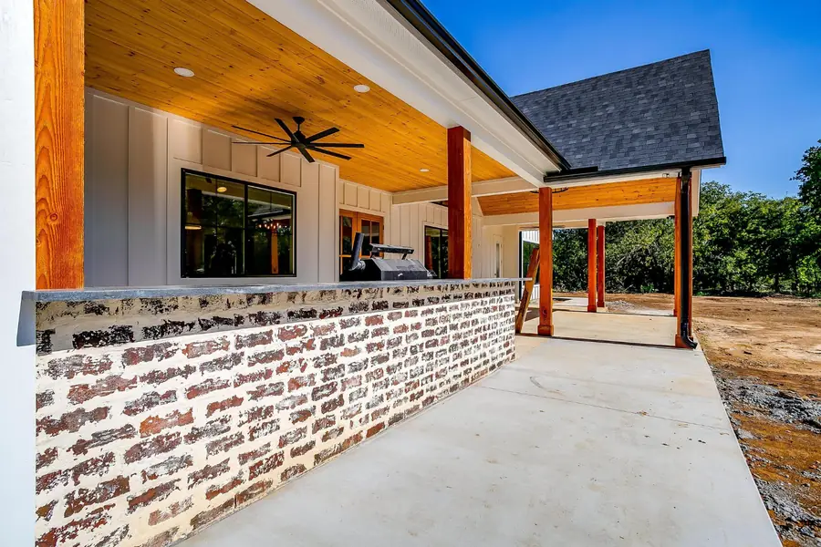 Covered back porch with cedar posts, a brick bar, and a wood ceiling