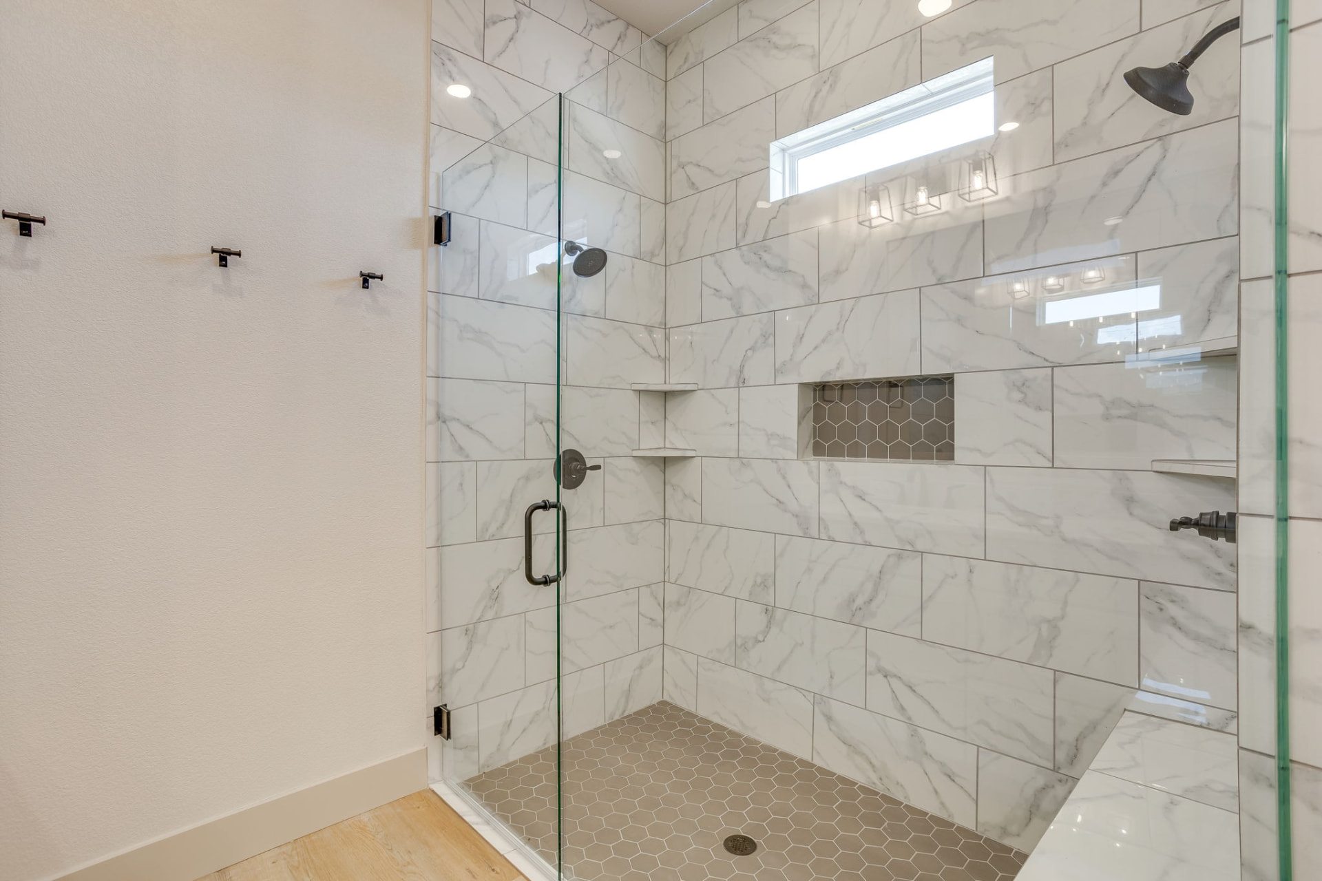 Walk-in shower with white tile walls and a built-in niche