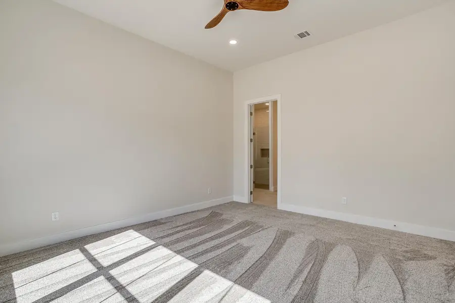 Primary bedroom suite with clean lines and a wood fan