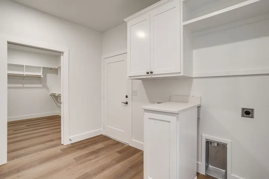 Laundry room with cabinetry, folding counter, and closet access