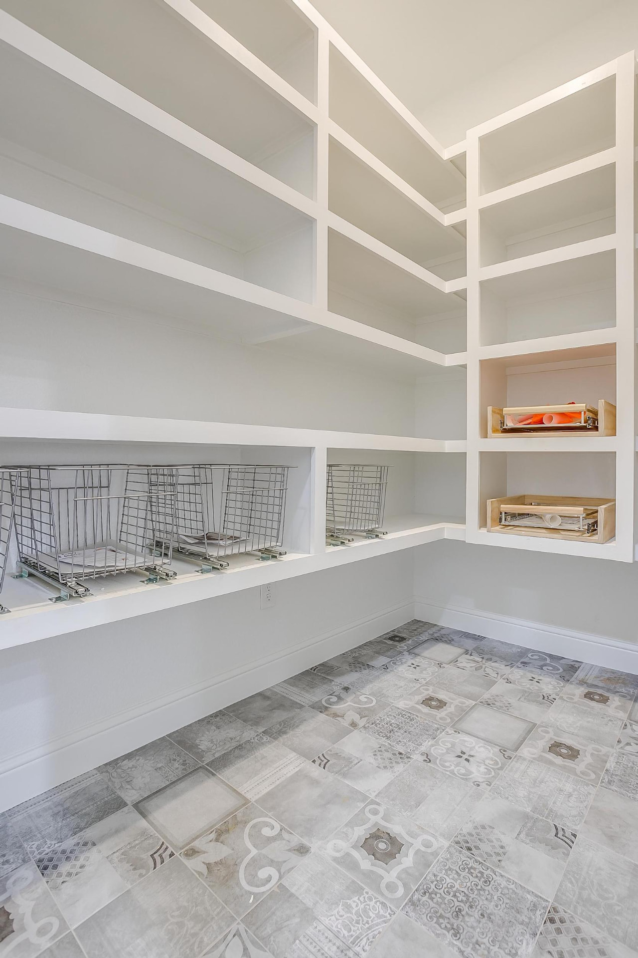 Walk-in pantry with white shelving and wire baskets