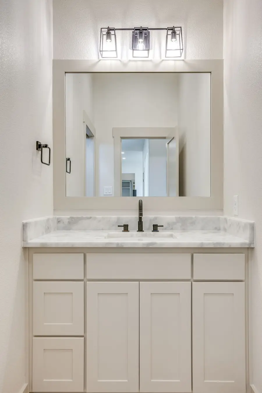Guest vanity with marble counters and bronze fixtures