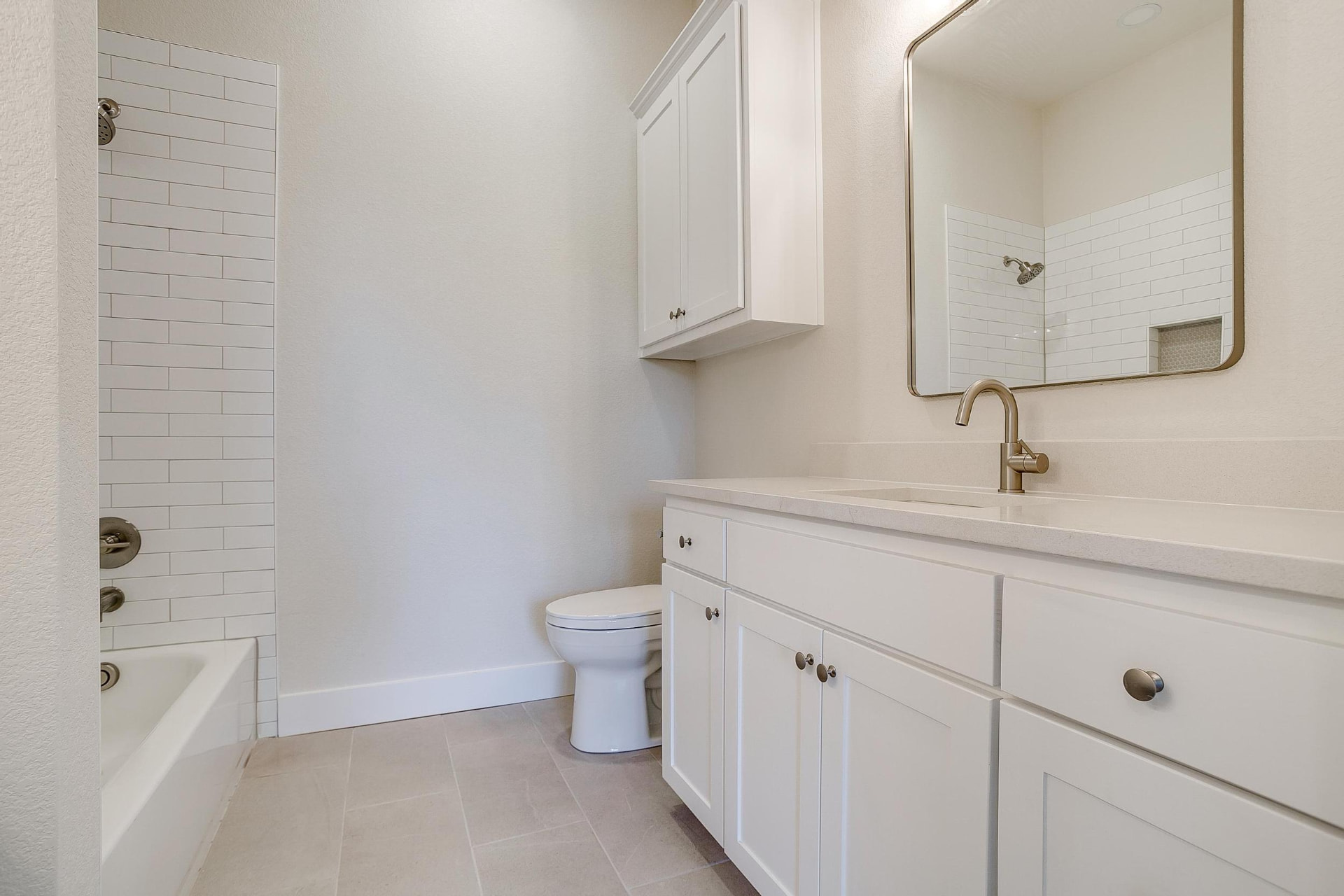 Guest bath with a white vanity and tiled tub-shower