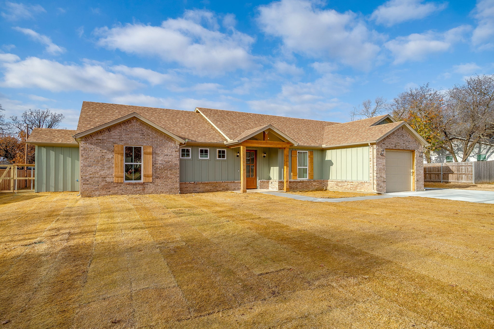 Angled front elevation of the 436 Wicker Way custom home showing wood shutters and gabled roofline