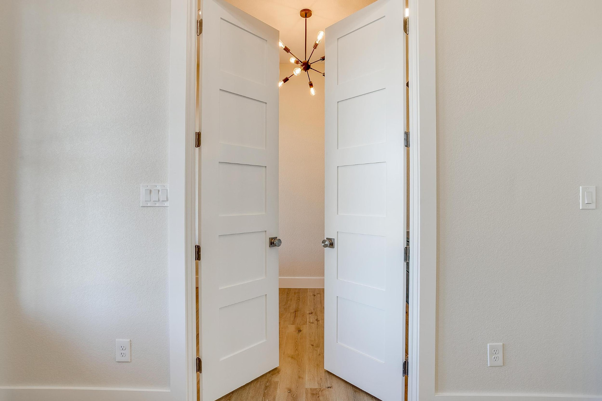 White double doors opening into the lit home office