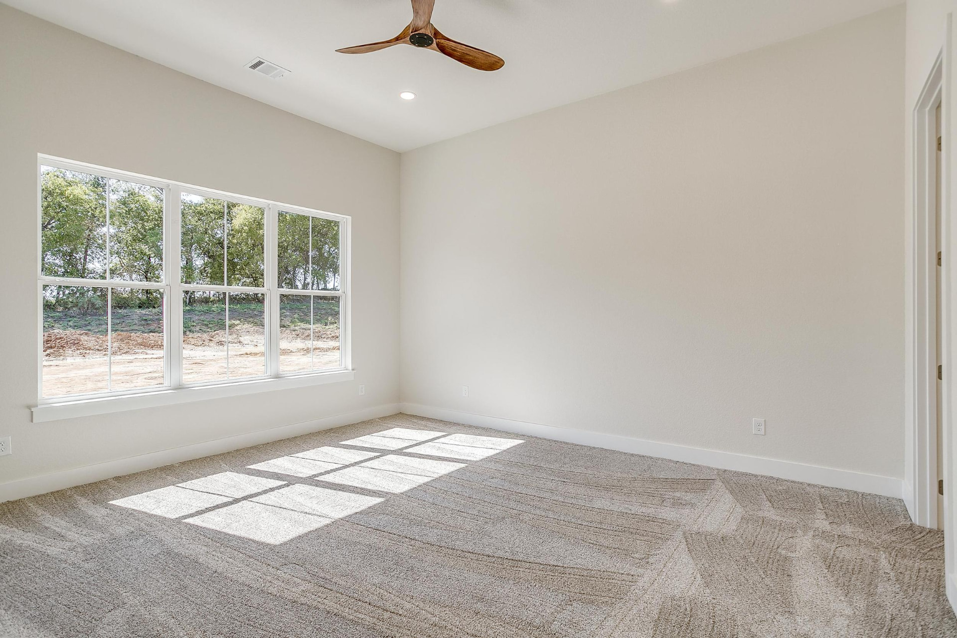Bedroom with large windows, plush carpet, and a wood ceiling fan
