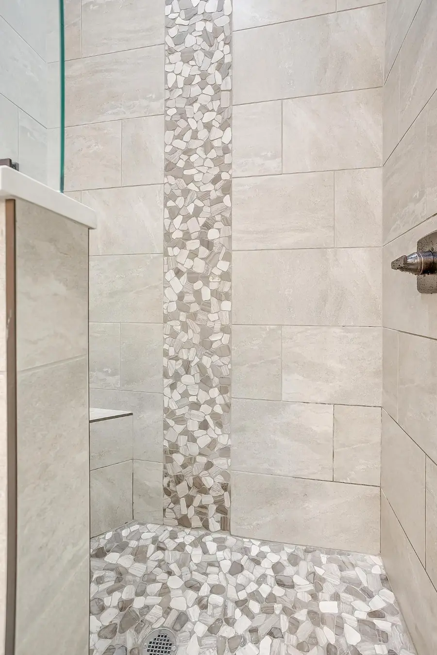 Tiled shower with pebble stone flooring