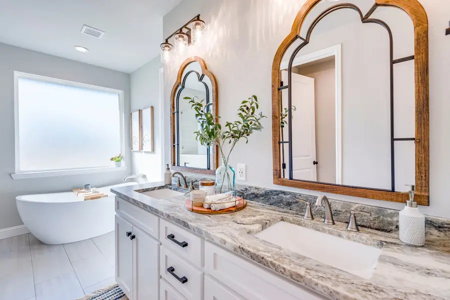 Bathroom double vanity with marble tops and wood-framed mirrors