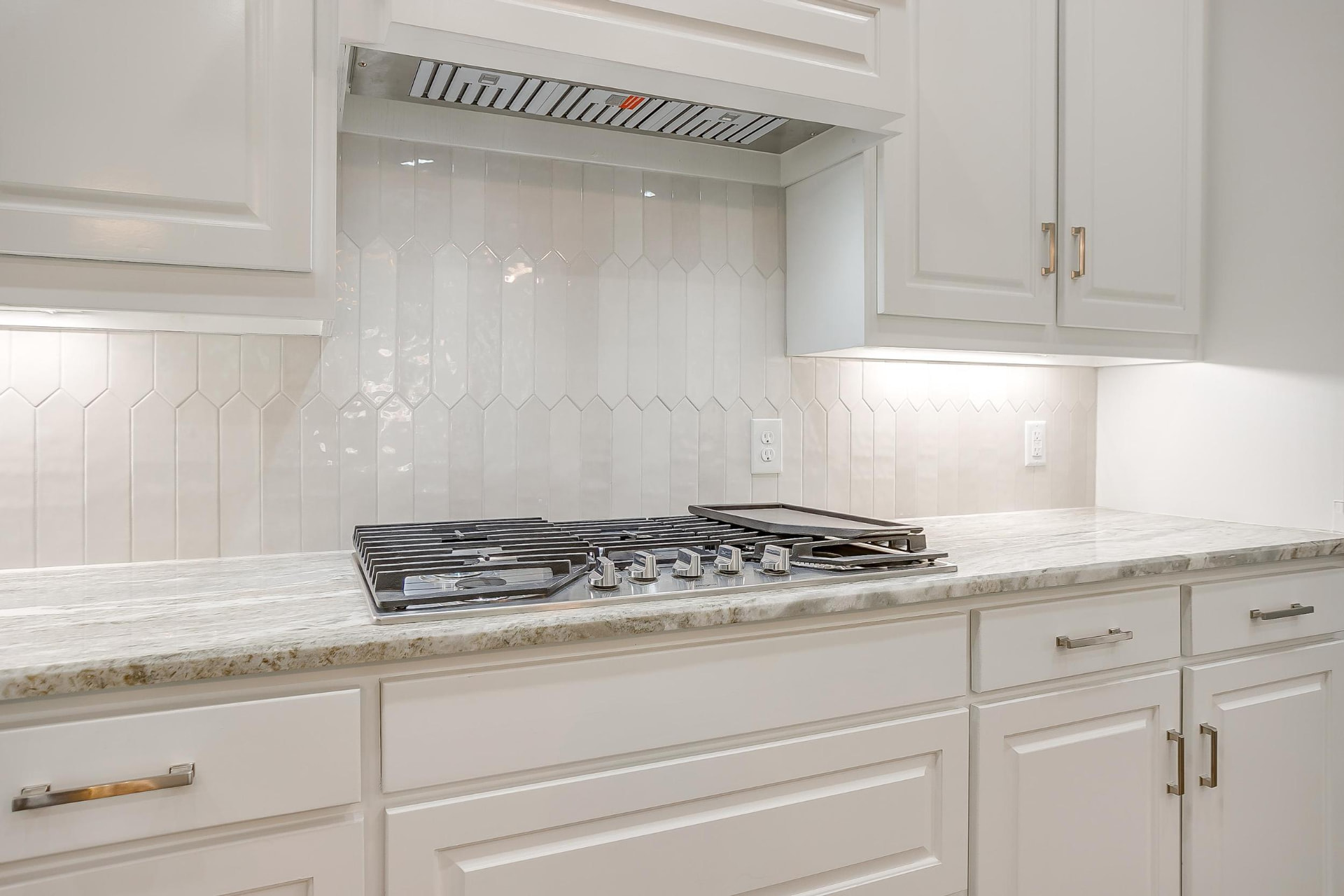 Gas range with white subway tile backsplash