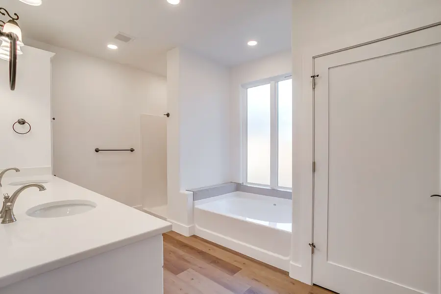 Primary bath with double vanity, soaking tub, and walk-in shower