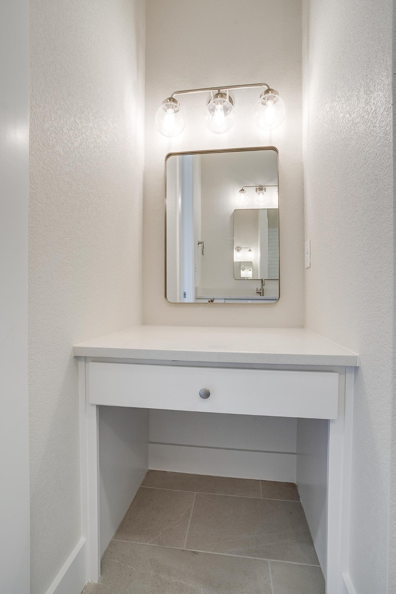 Built-in makeup vanity nook with a lit mirror