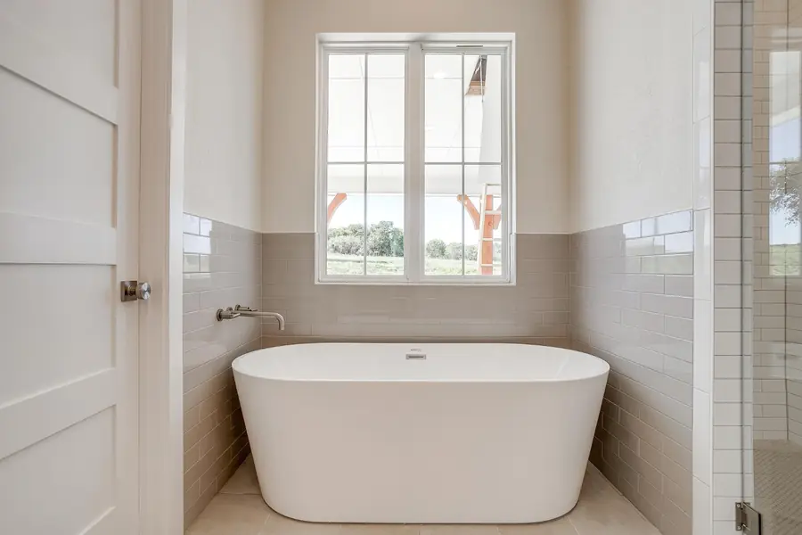 Soaking tub centered beneath a bright window