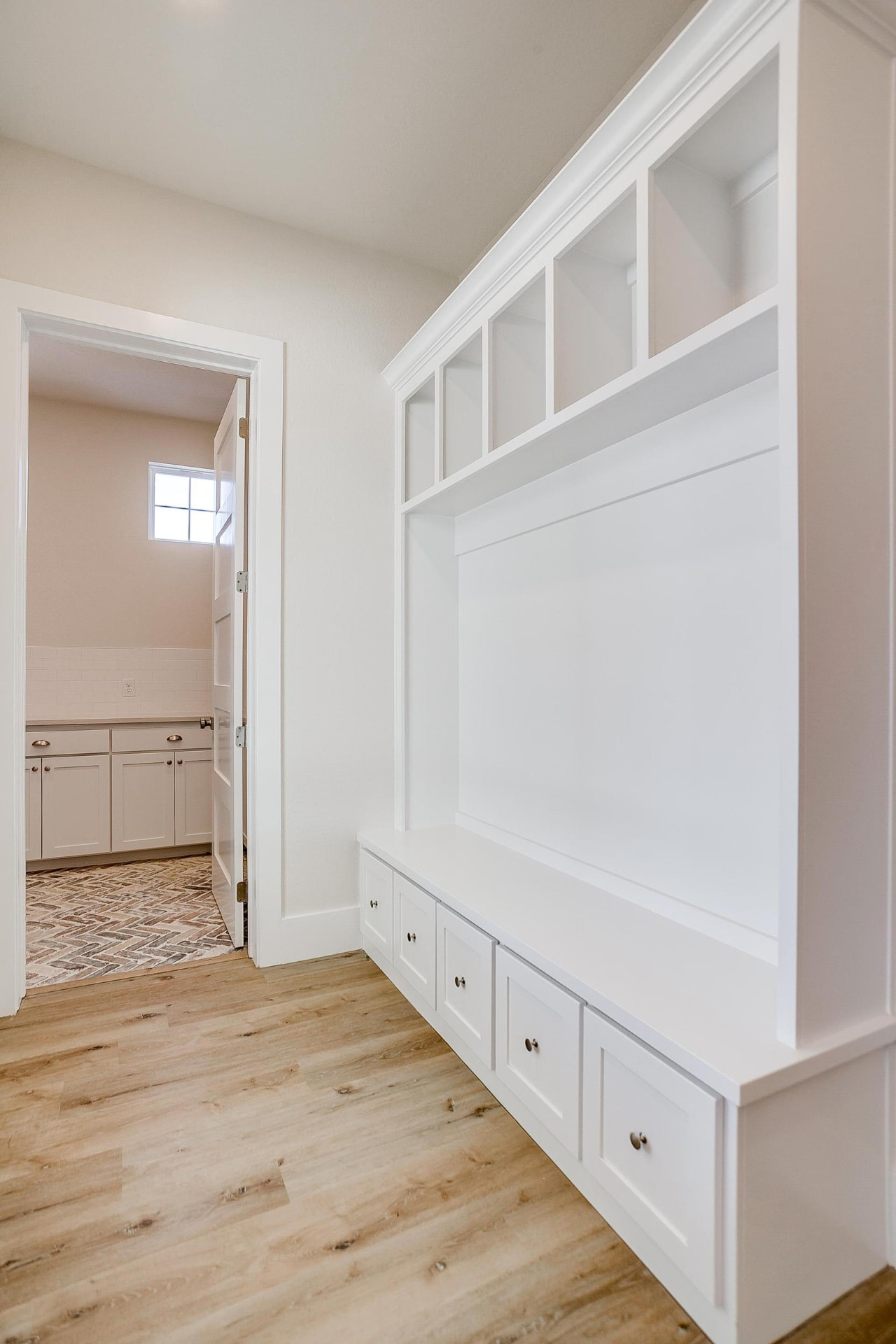 Mudroom with a white built-in bench and cubby storage