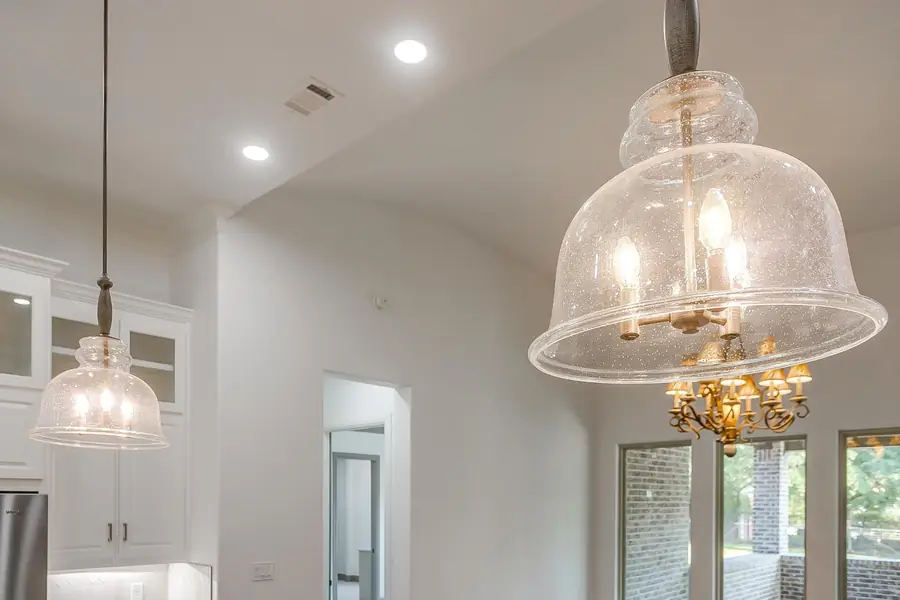 Detail of a clear glass pendant light over the island