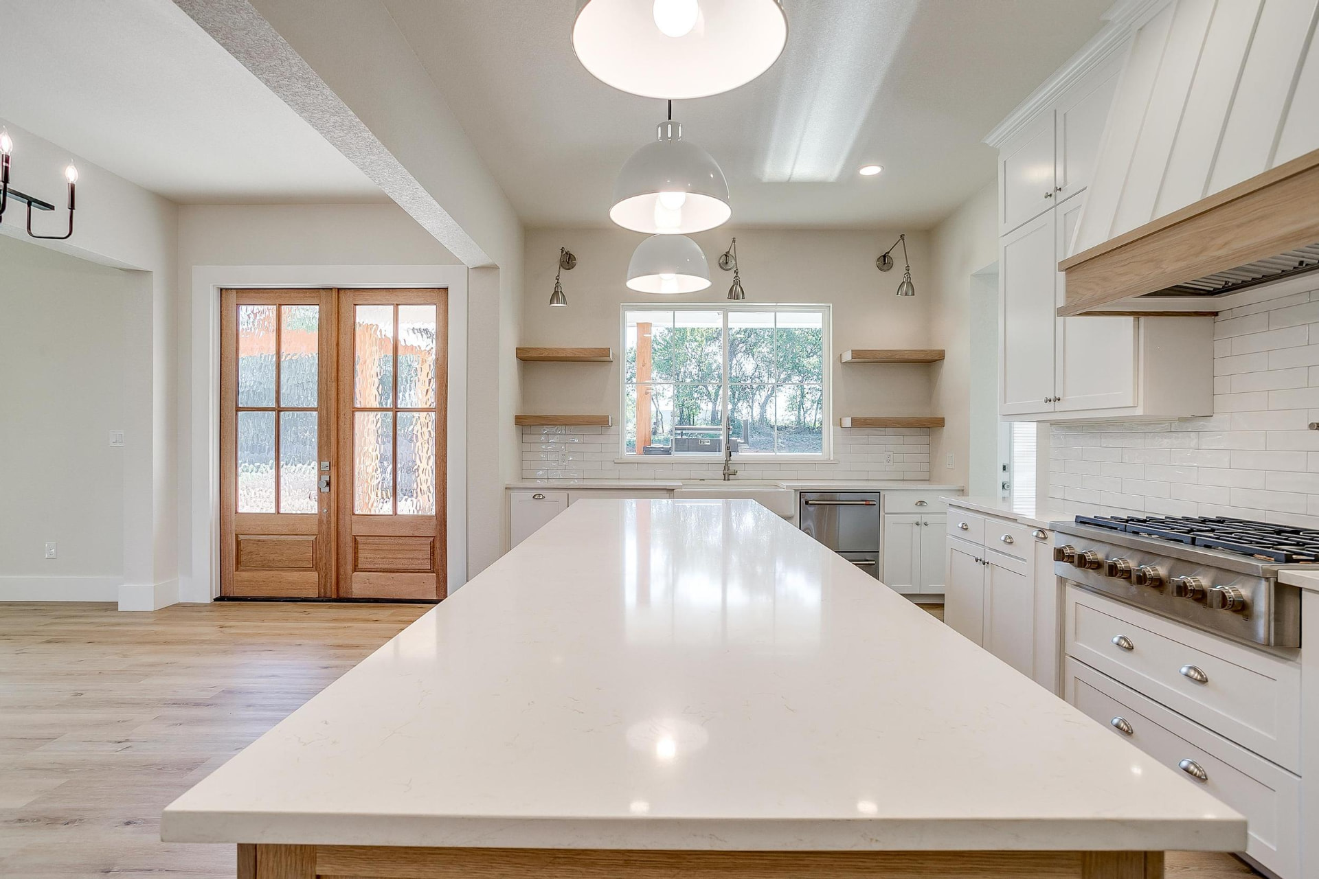Farmhouse sink window with natural wood floating shelves