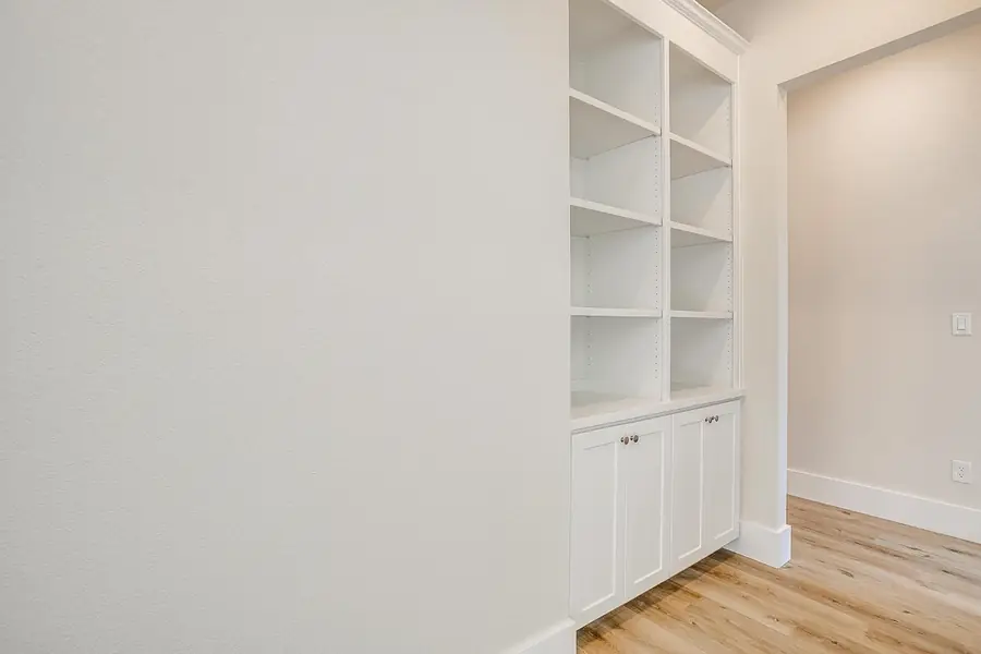 Hallway with built-in white bookshelves and cabinetry