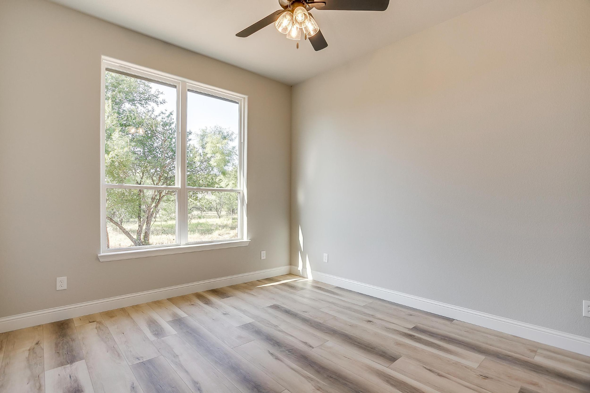Bright bedroom with a large window overlooking mature trees