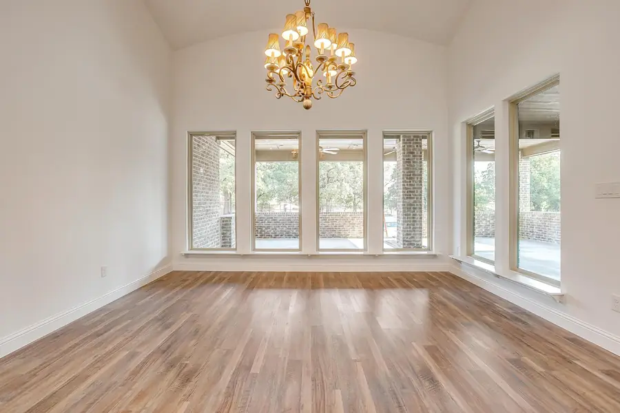 Dining area with vaulted ceiling and iron chandelier