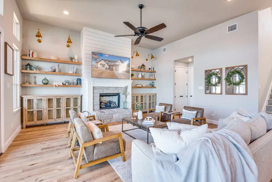 Living room with shiplap fireplace, built-in shelving, and mounted TV