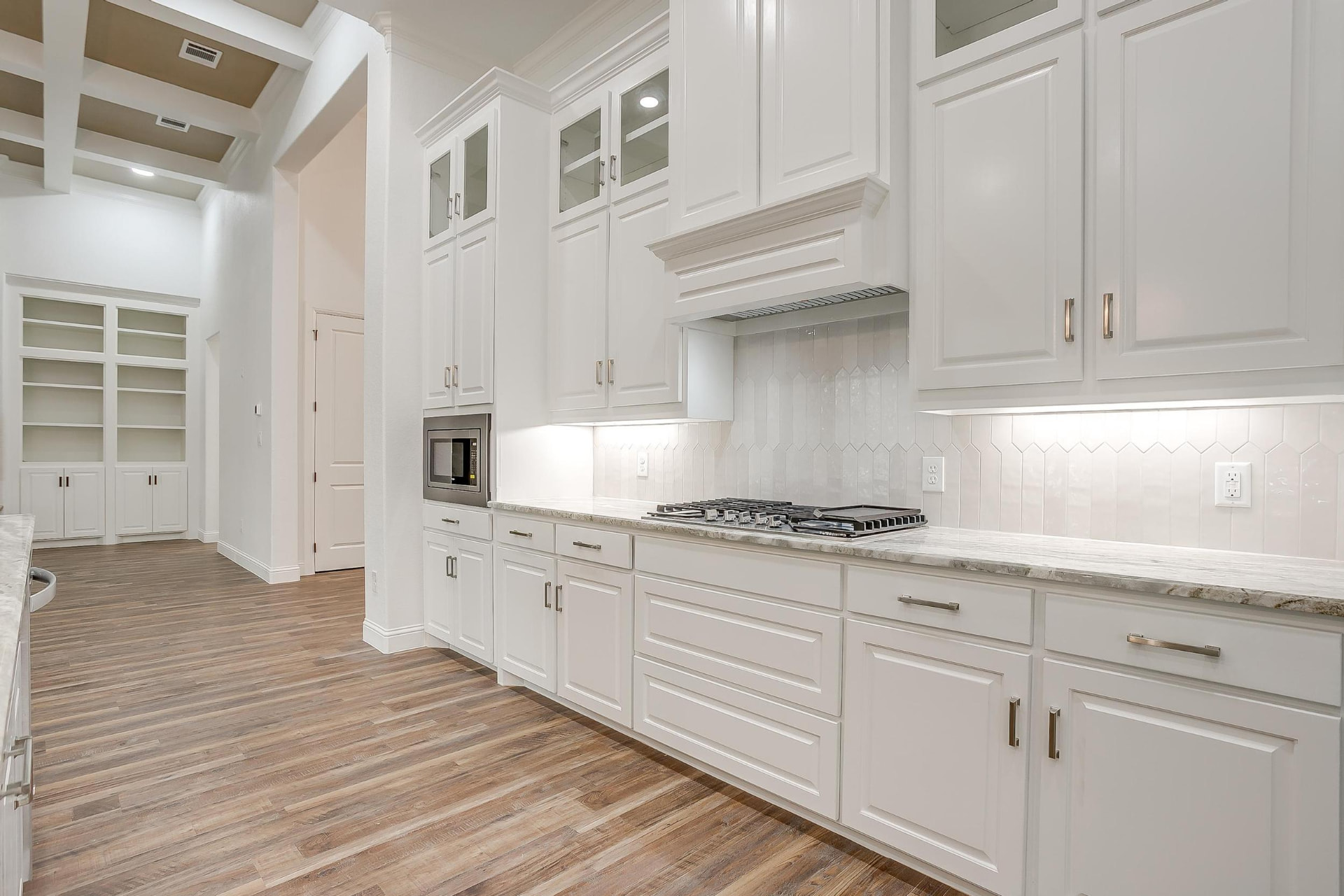 White kitchen cabinets with the built-in library beyond