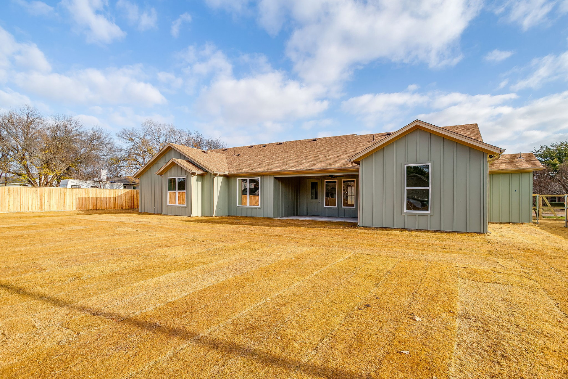 Wide rear elevation of the custom home and detached storage building