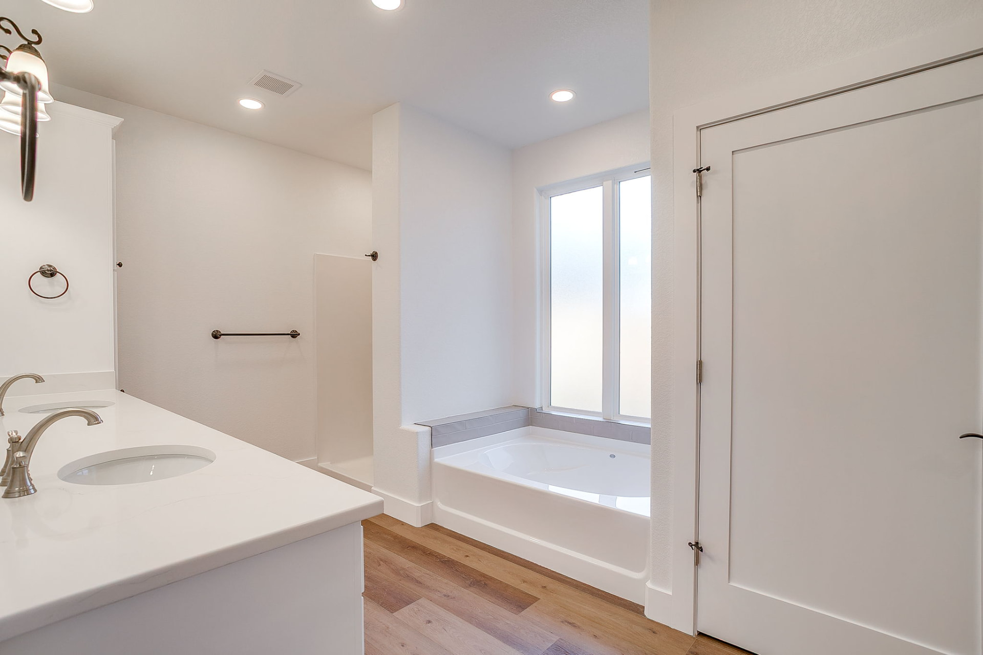 Primary bath with double vanity, soaking tub, and walk-in shower