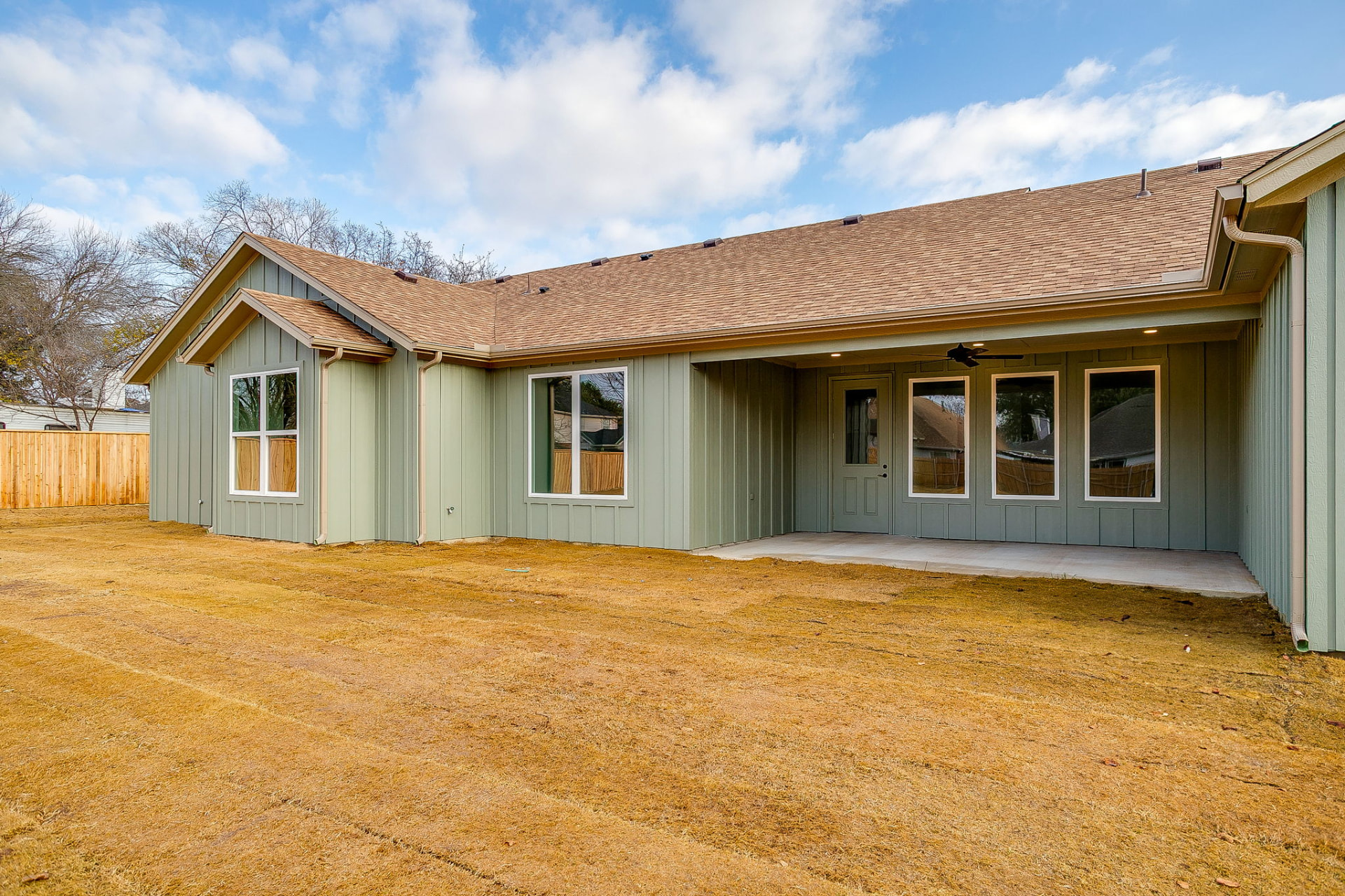 Rear exterior of the Wicker Way custom home with covered patio and board-and-batten siding