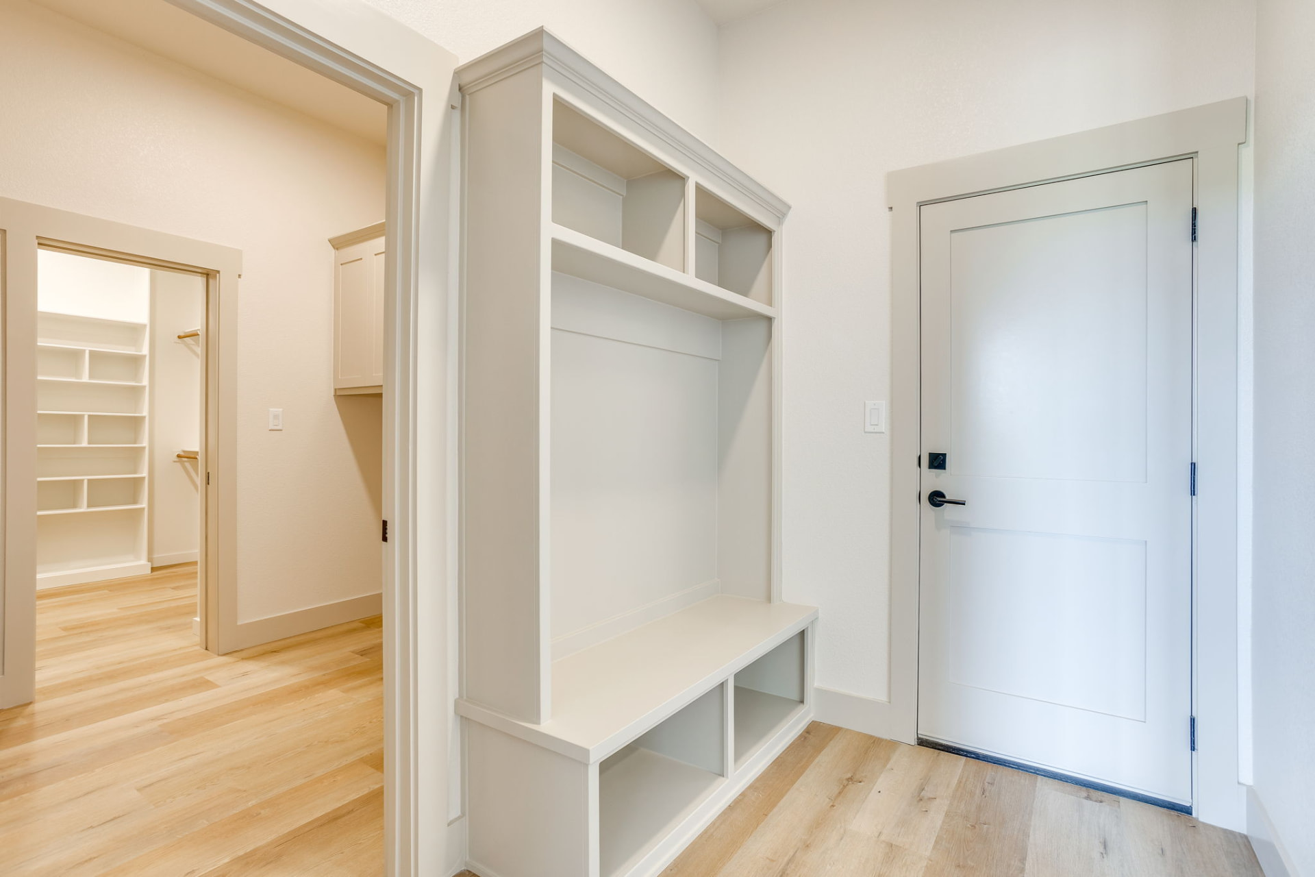 Mudroom with a white built-in bench and cubby storage