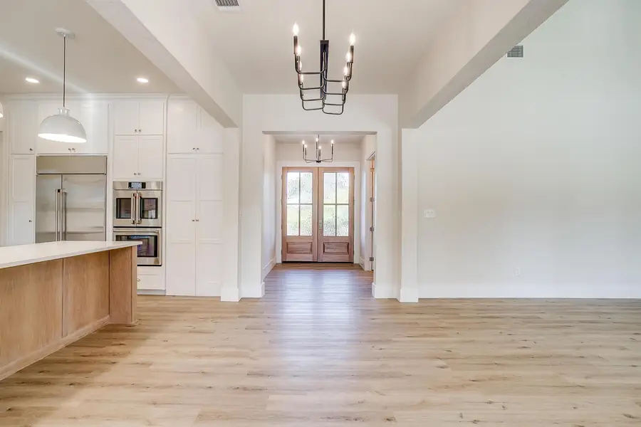 Foyer looking toward the wood front doors with the kitchen island at left