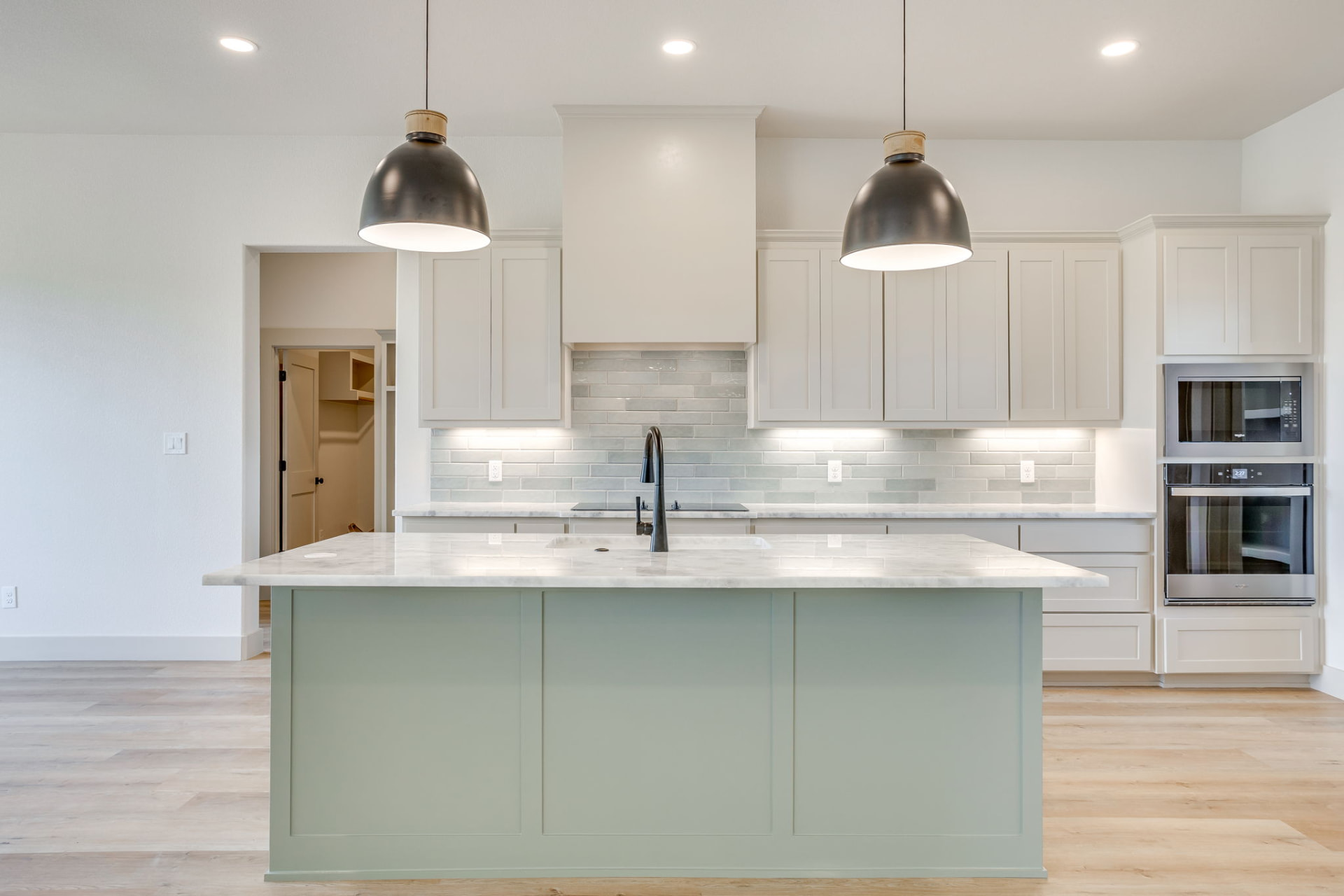 Sage green kitchen island with a marble top