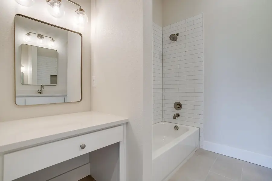 Bath with a built-in makeup vanity and tiled tub surround