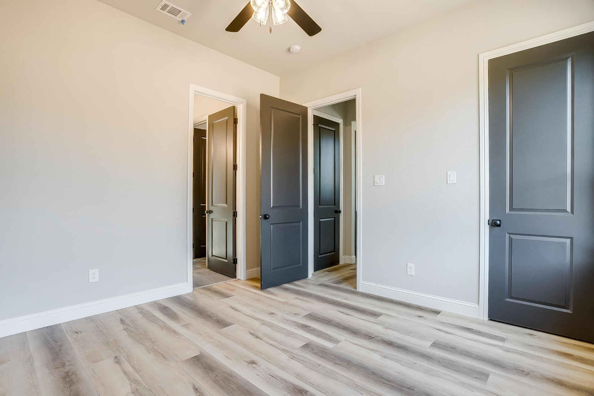 Bedroom with multiple dark gray doors and closet access