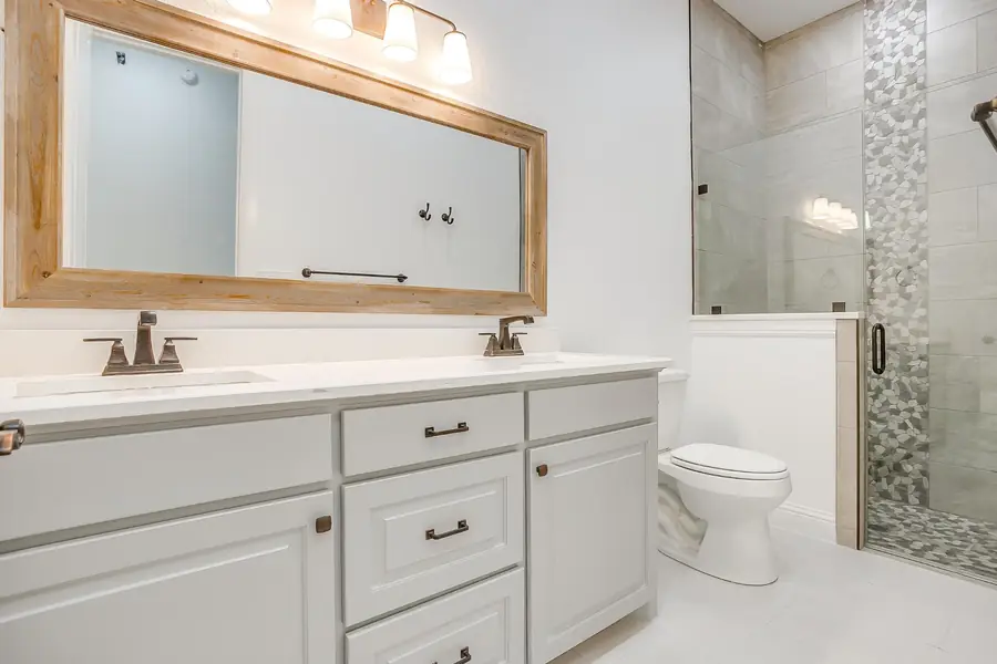 Guest bath with double vanity and wood-framed mirrors