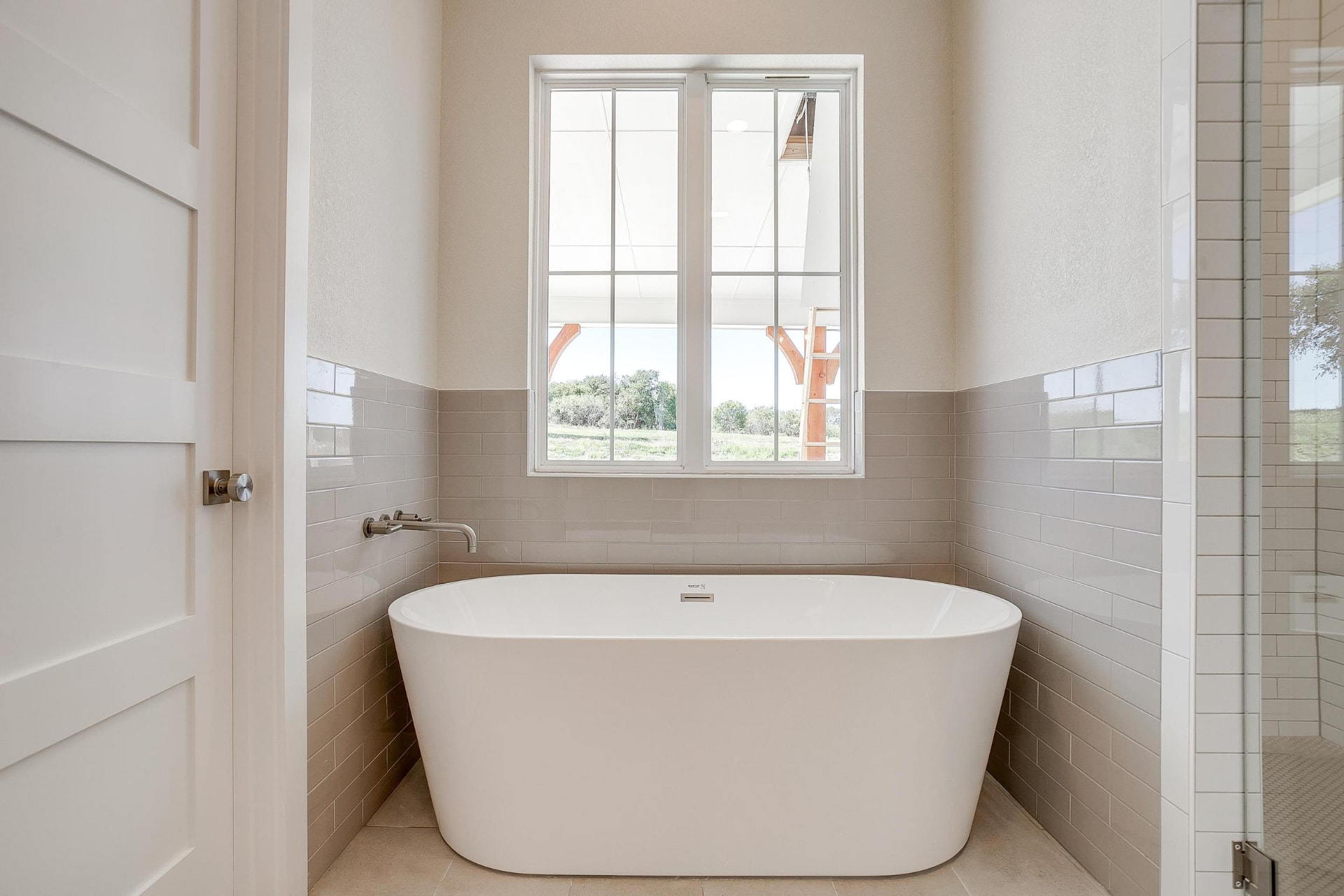 Soaking tub centered beneath a bright window