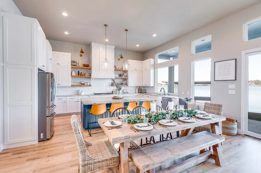 Dining area with a long wood table and navy kitchen island beyond