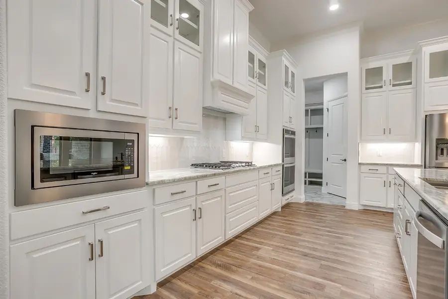 Stainless microwave built into white shaker cabinetry