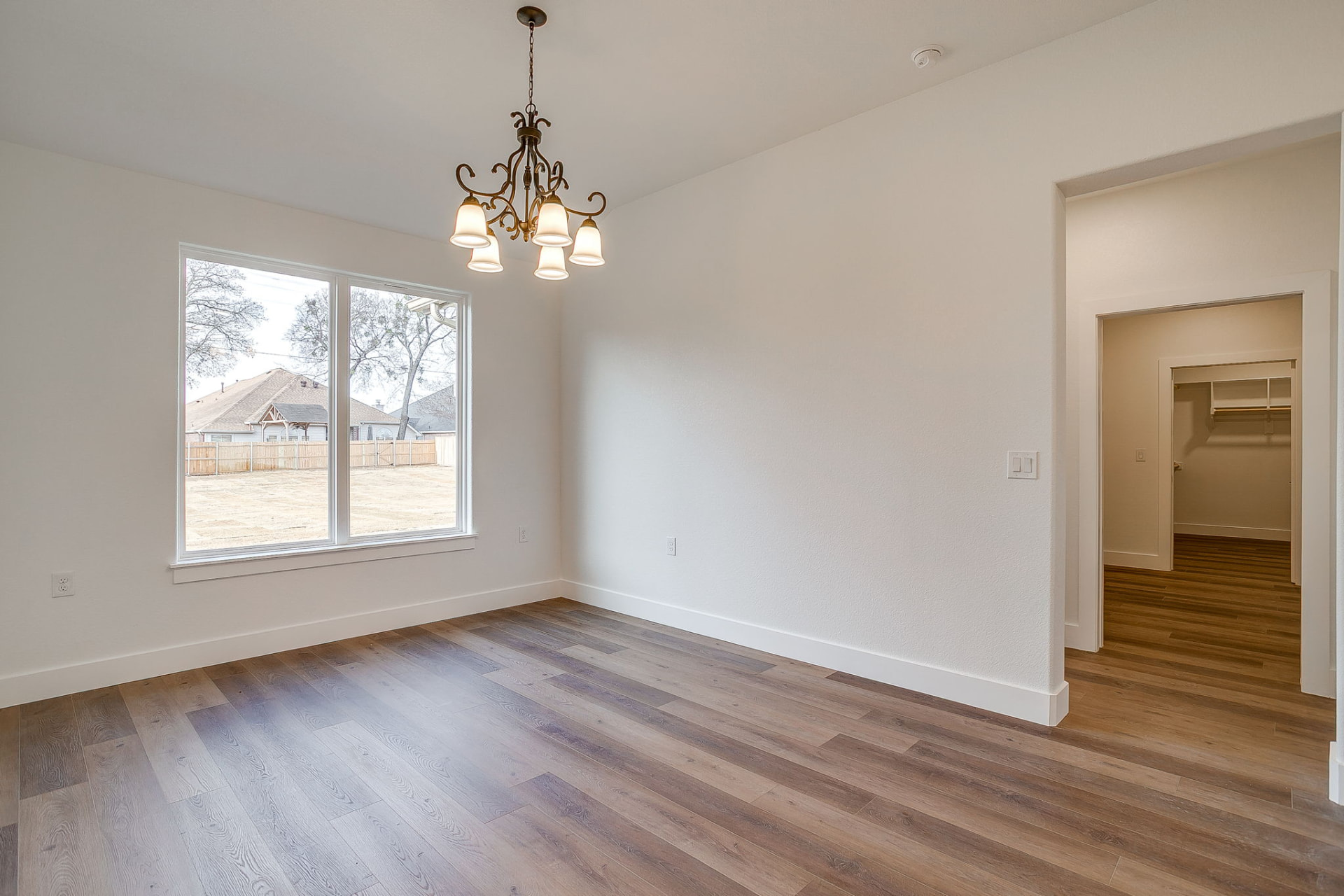 Hallway with wide-plank flooring connecting the bedroom wing