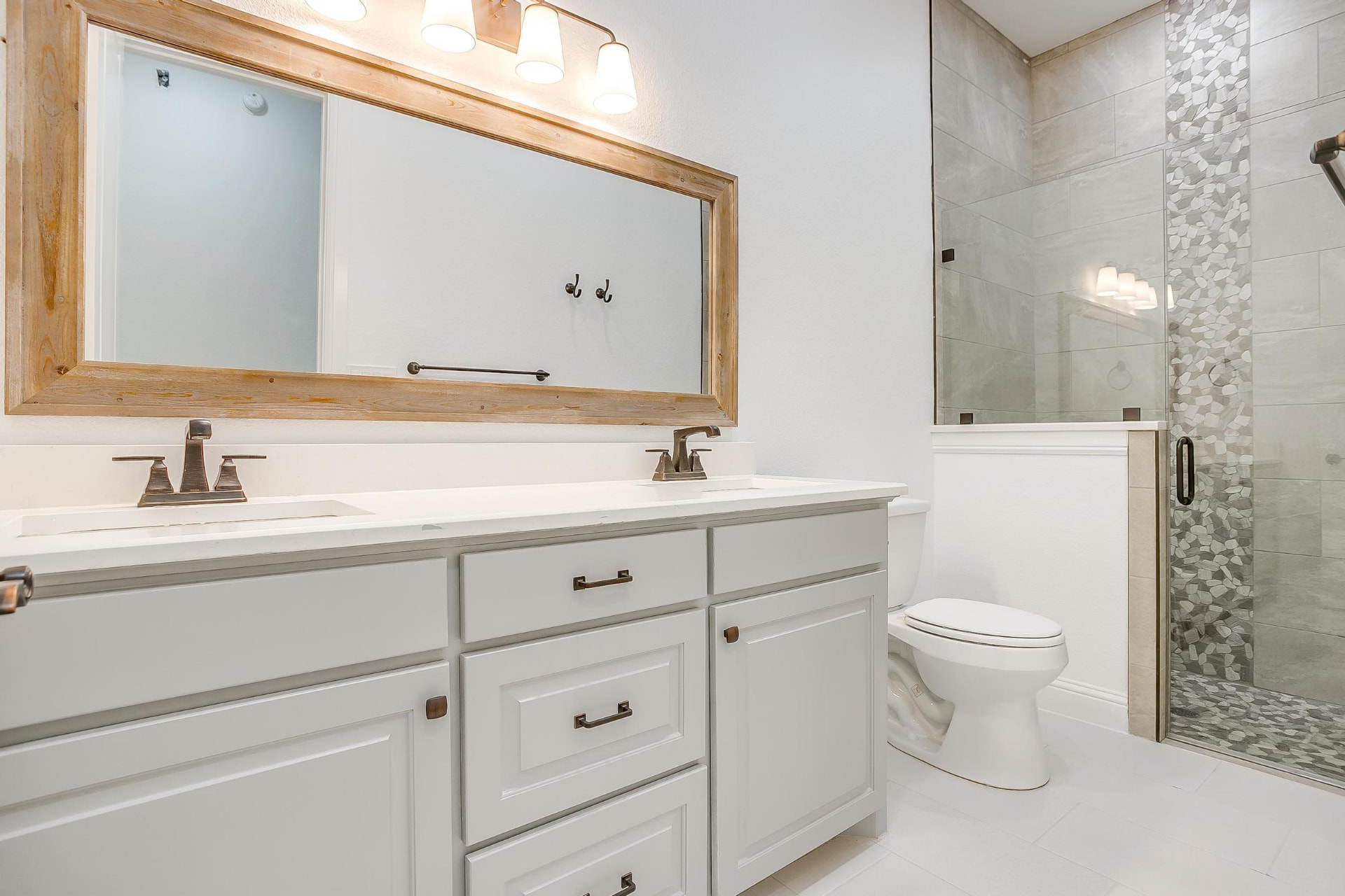 Guest bath with double vanity and wood-framed mirrors