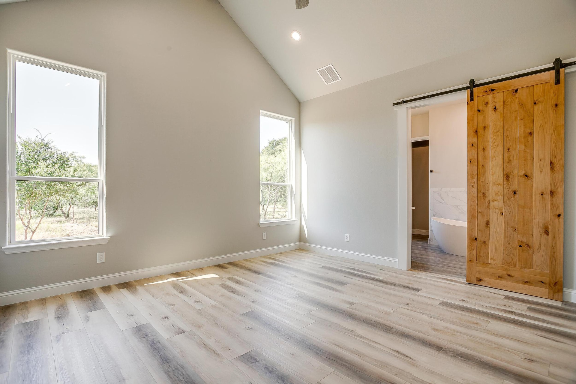Primary bedroom with sliding barn door to the ensuite
