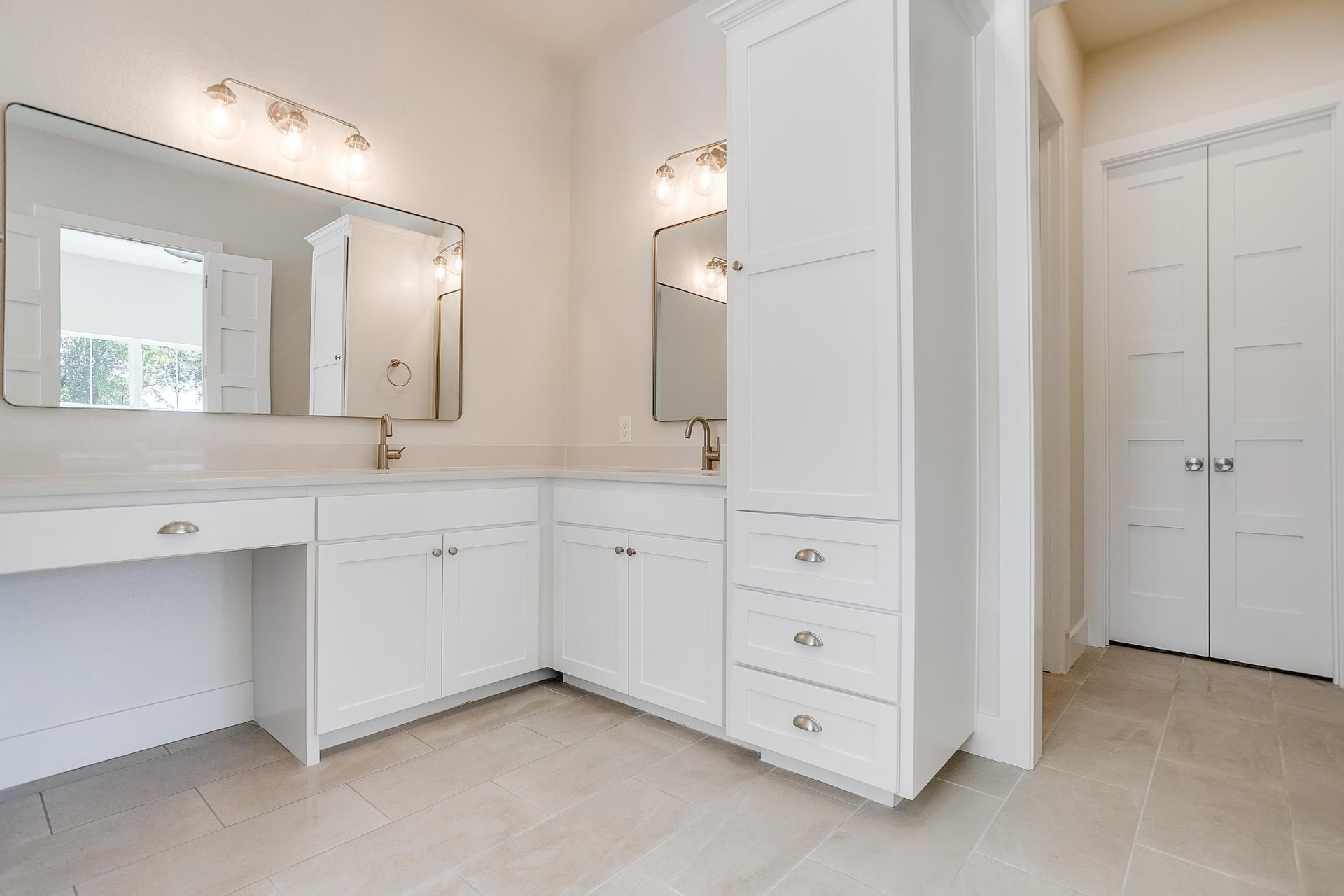Primary bathroom with dual vanities and a tall linen cabinet