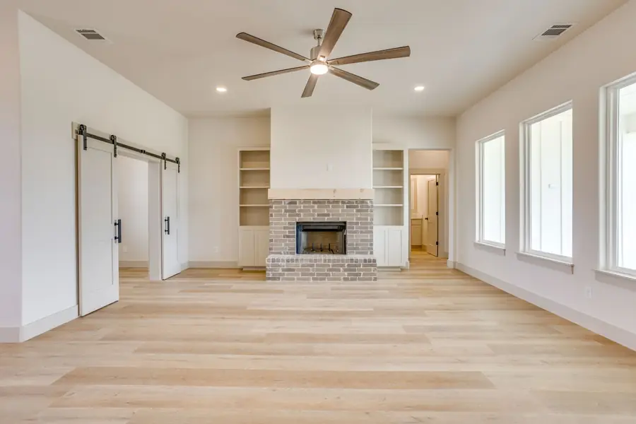Brick fireplace flanked by white built-in shelving