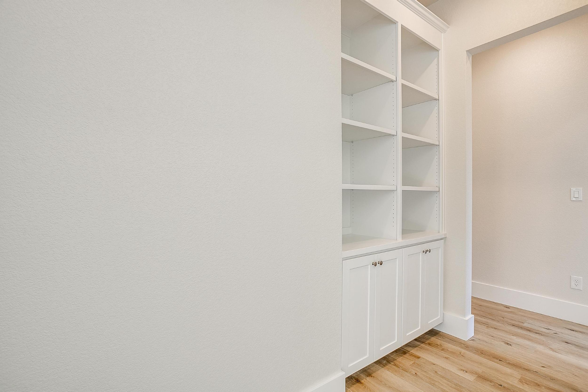 Hallway with built-in white bookshelves and cabinetry