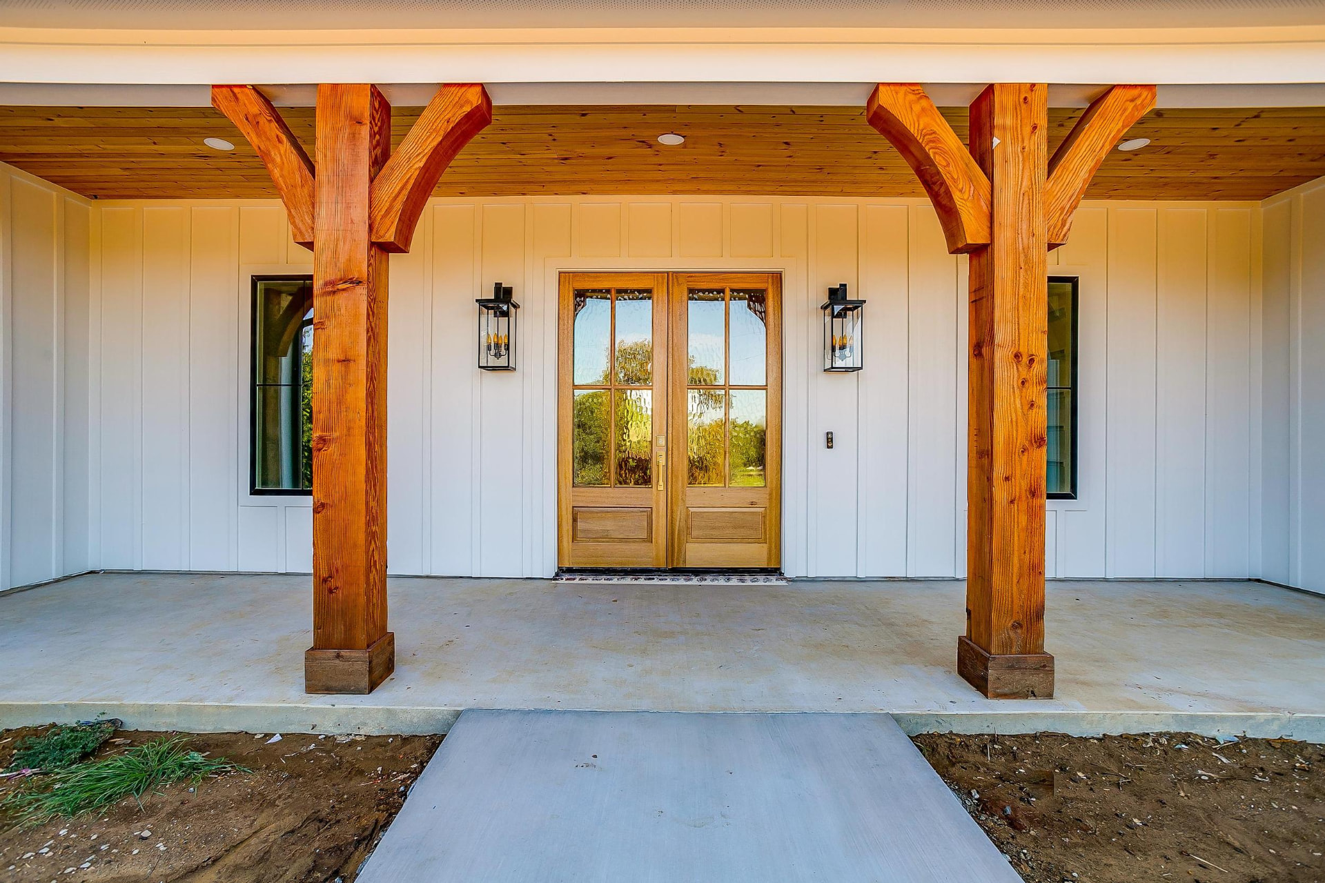 Front porch with natural cedar posts and a wood front door